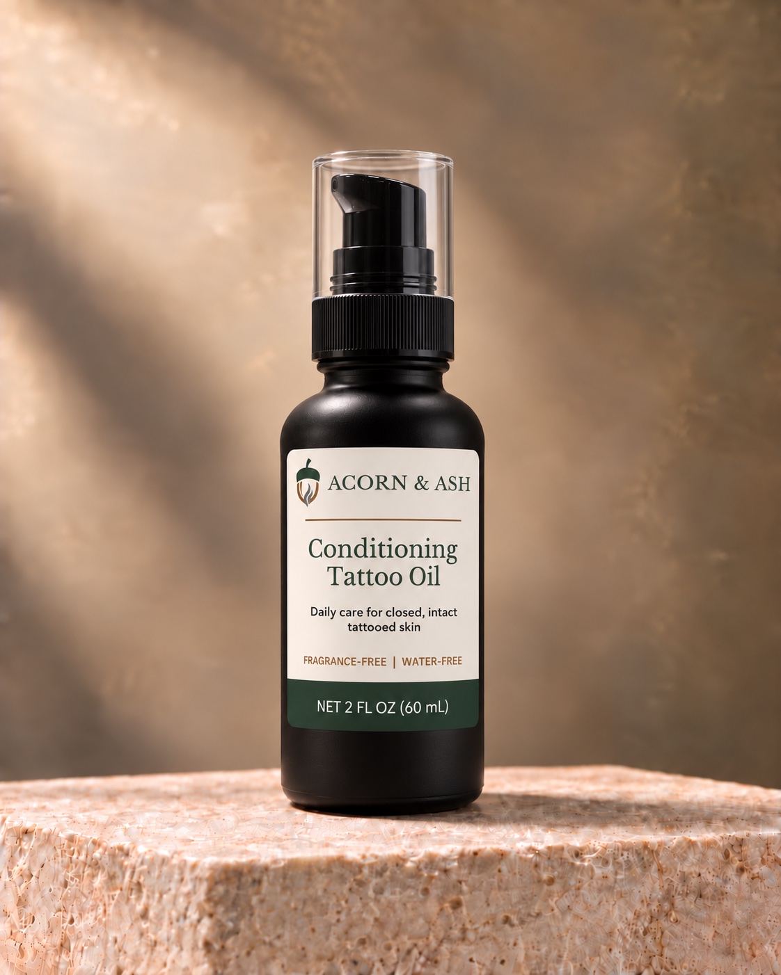 Conditioning Tattoo Oil in a dark pump bottle with the previous Acorn & Ash label design